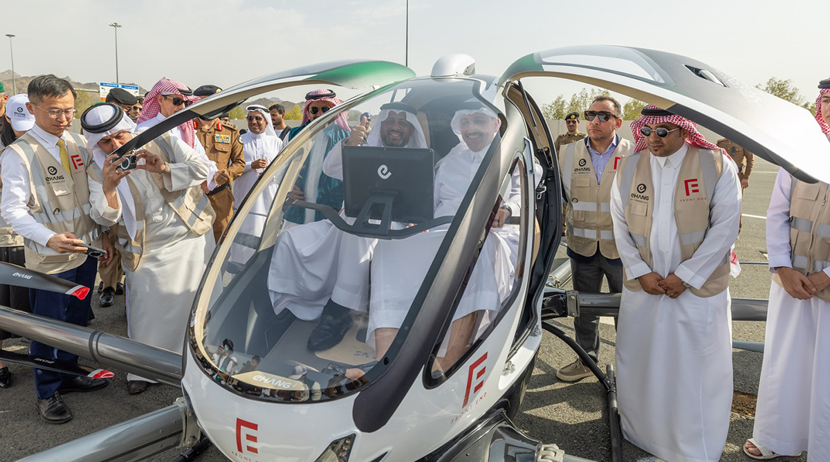 Crowds swarm around the air taxi after its successful trial flight in Mecca